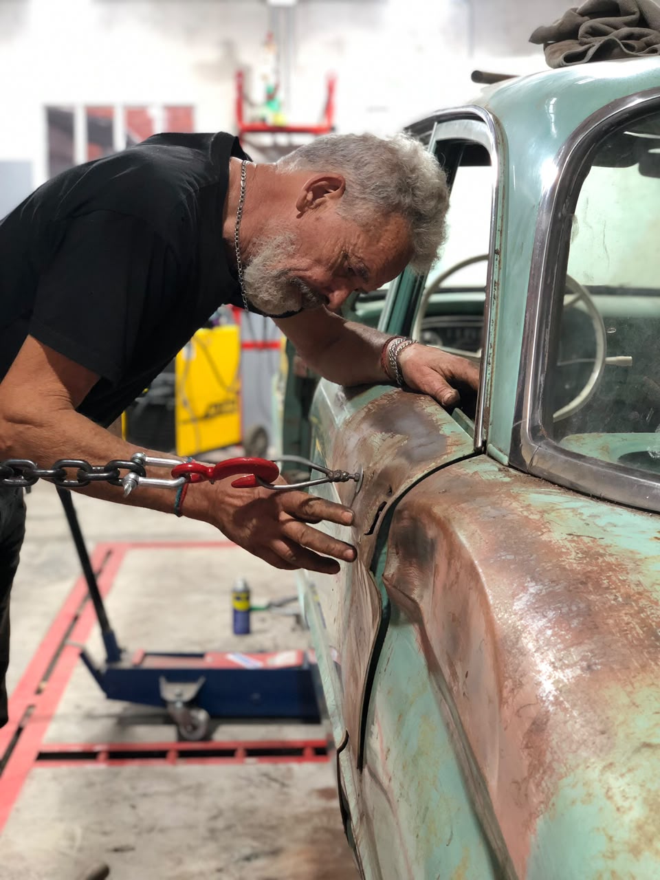 Roberto Scenna mostrando una reparacion de chapa automotriz en taller